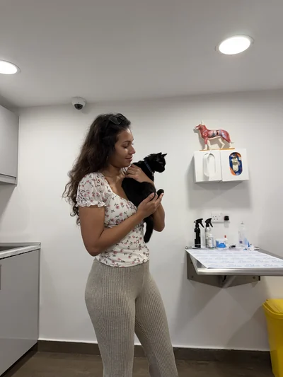 Mon épouse tenant notre chat noir dans un cabinet vétérinaire