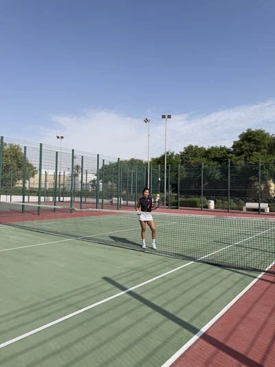 Mon épouse au service sur un court de tennis, en plein jour