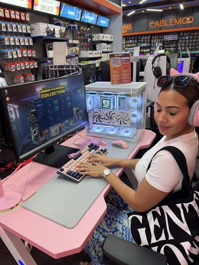 Mon épouse dans un magasin d'informatique, casque sur les oreilles, devant un ordinateur