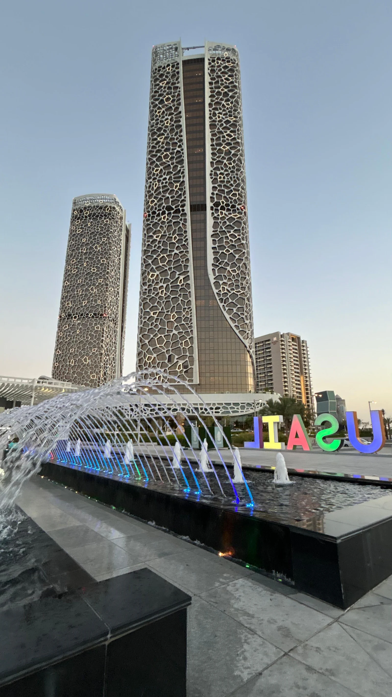 Lettres colorées formant le nom de Lusail devant les tours du quartier
