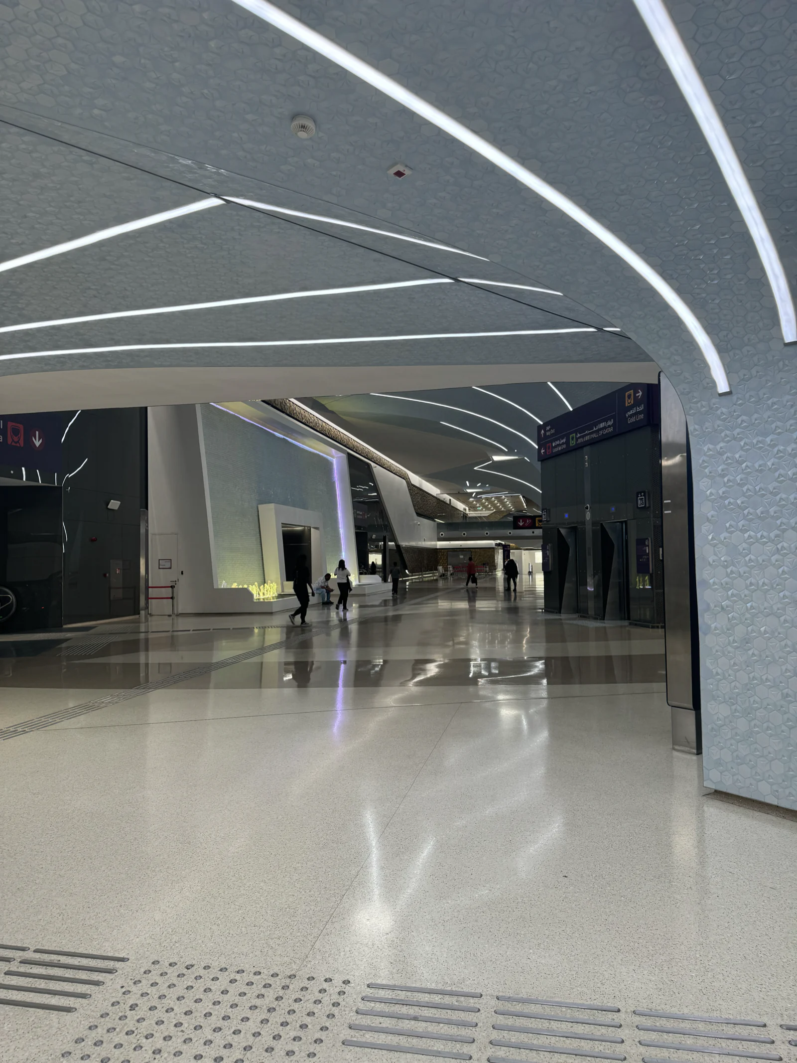 Galerie piétonne climatisée en sous-sol à Msheireb, plafond incurvé et bandeaux lumineux
