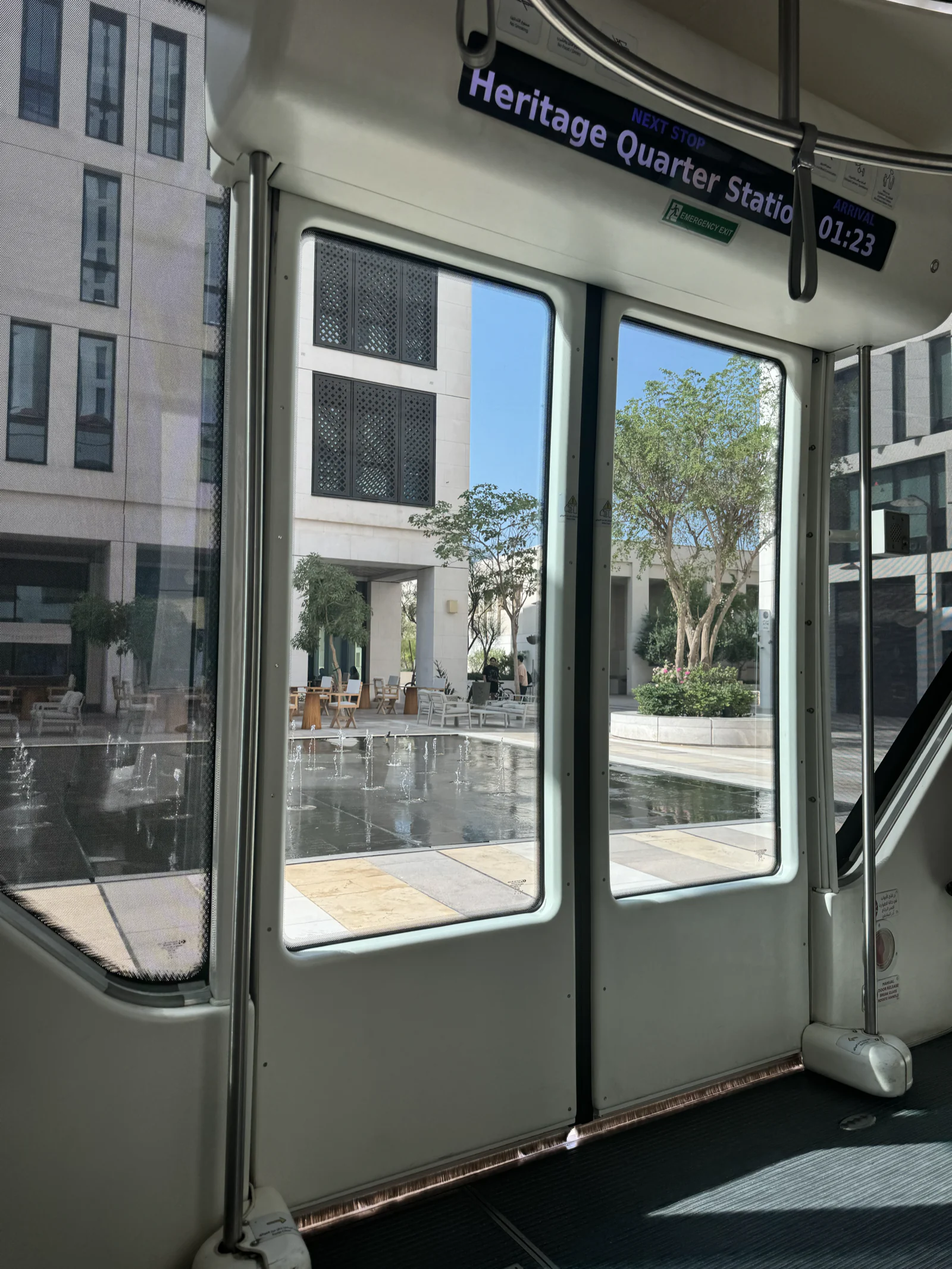 Intérieur du tram de Msheireb à l'arrêt Heritage Quarter Station, vue sur la rue à travers les portes vitrées
