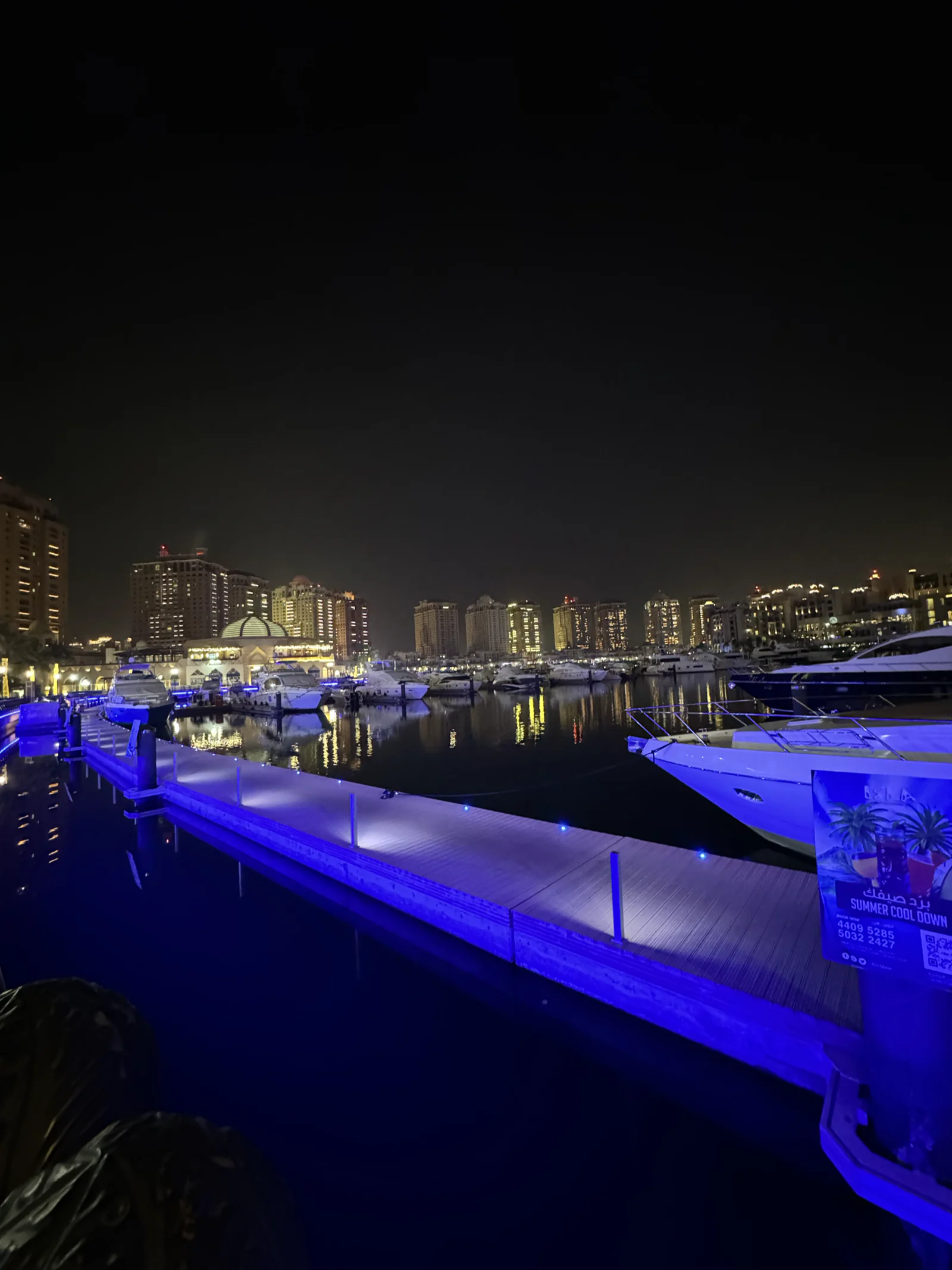 Les pontons et les yachts de Porto Arabia éclairés de bleu, la nuit