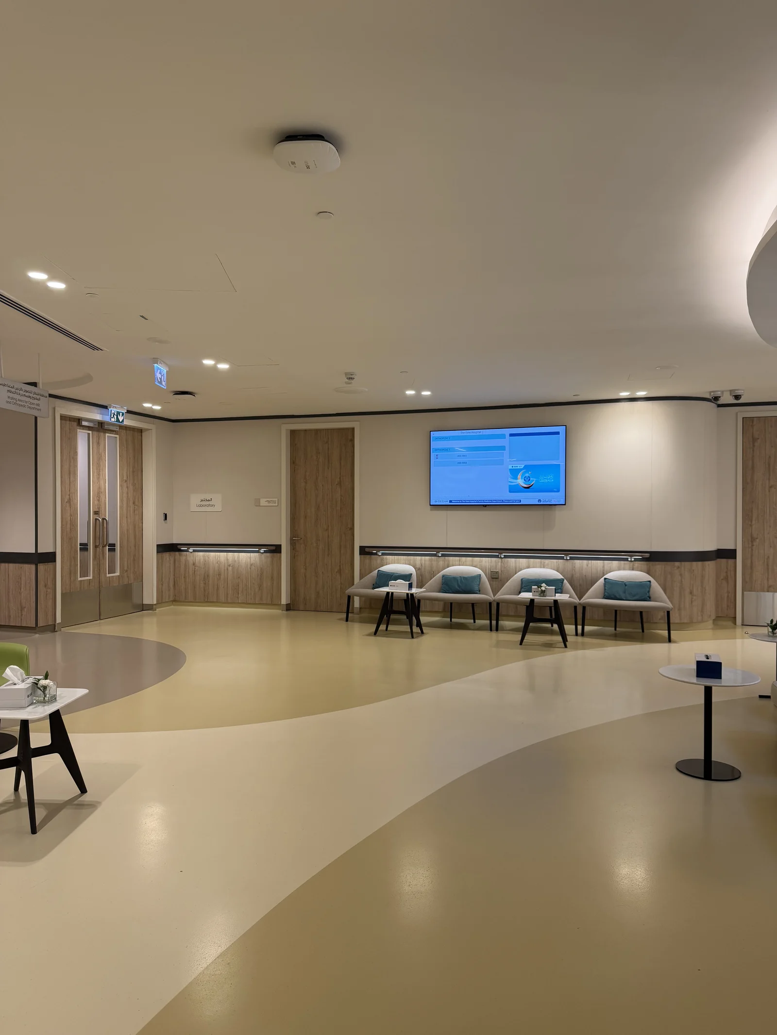 Une salle d'attente avec écran d'information, banquette et guichets d'accueil
