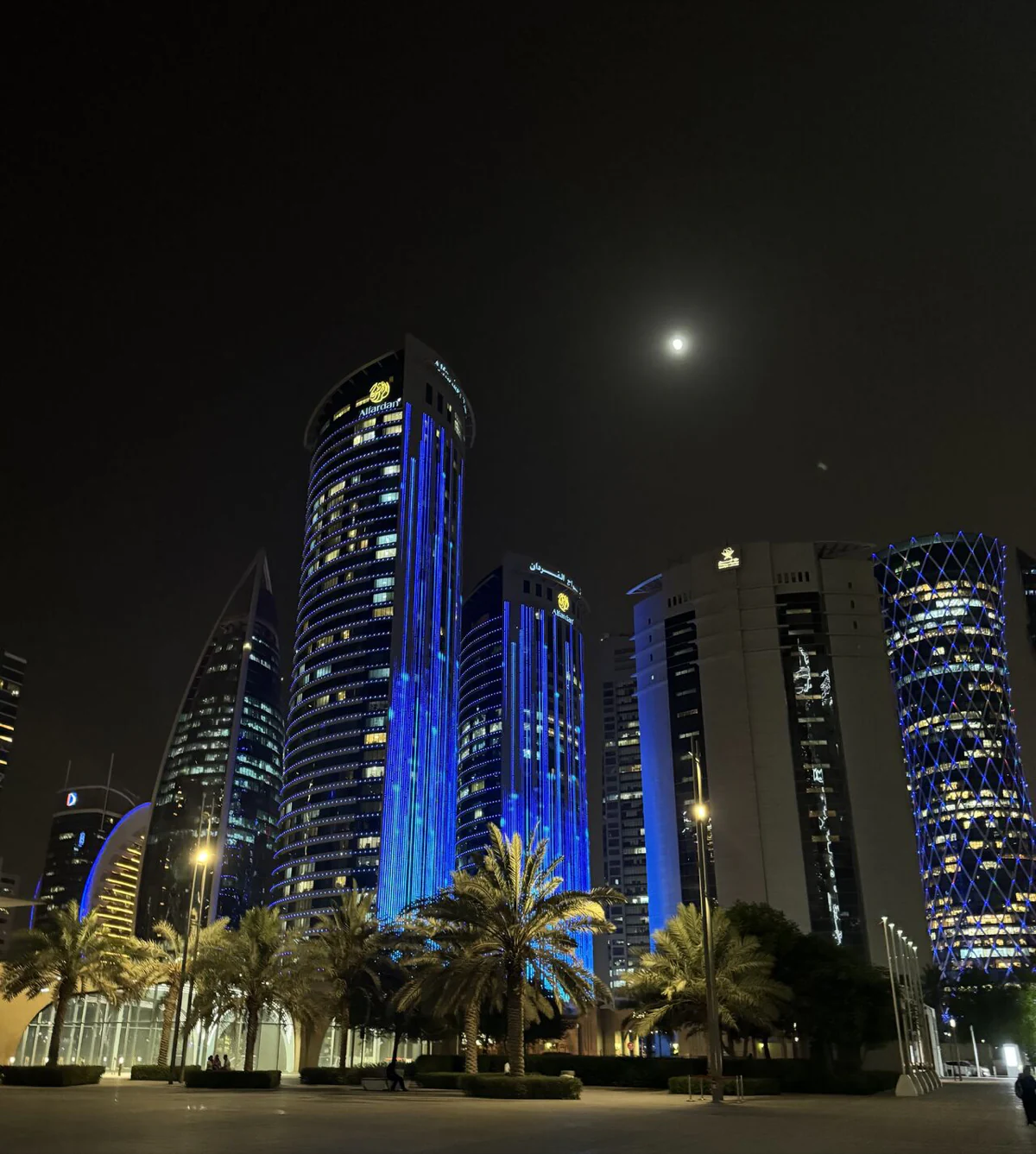 Les tours de West Bay illuminées en bleu la nuit, sous la lune
