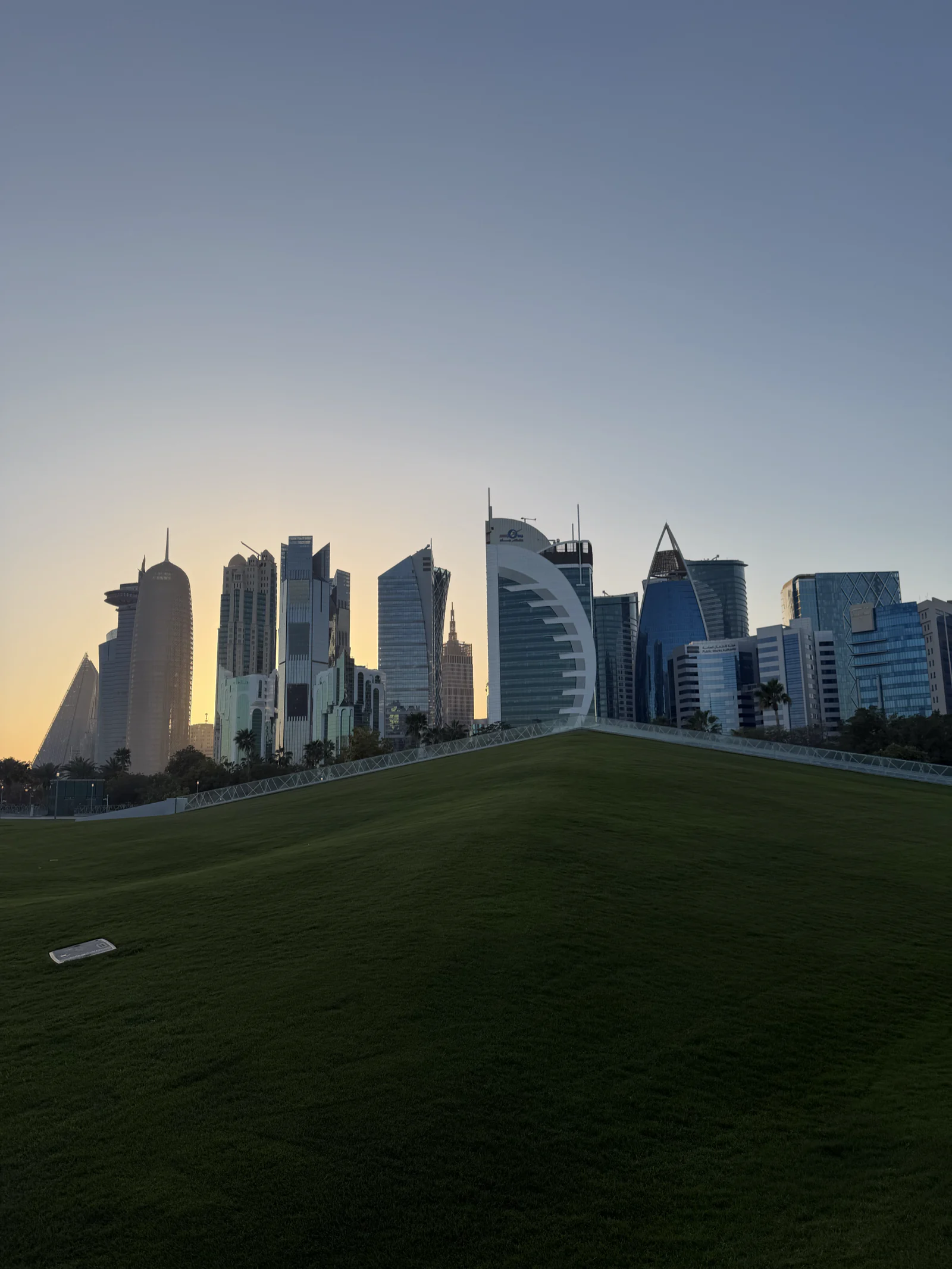 La skyline de West Bay au crépuscule, vue depuis une pelouse en pente